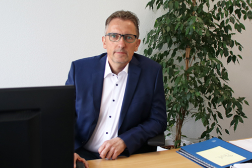 Herr Jürgenheinzelmann am Schreibtisch